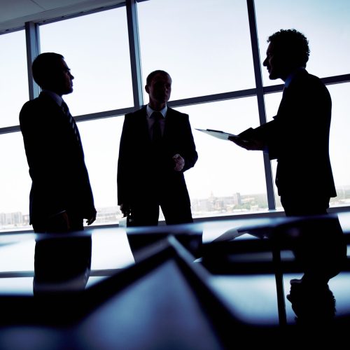 Shady business Shady image of a manager discussing business matters with his subordinates